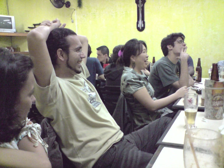 several people sitting in a row drinking beers