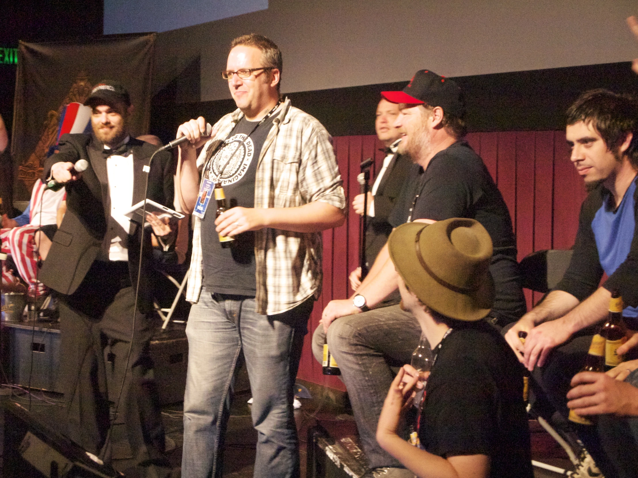 a man standing at the microphone while someone holds his hand up