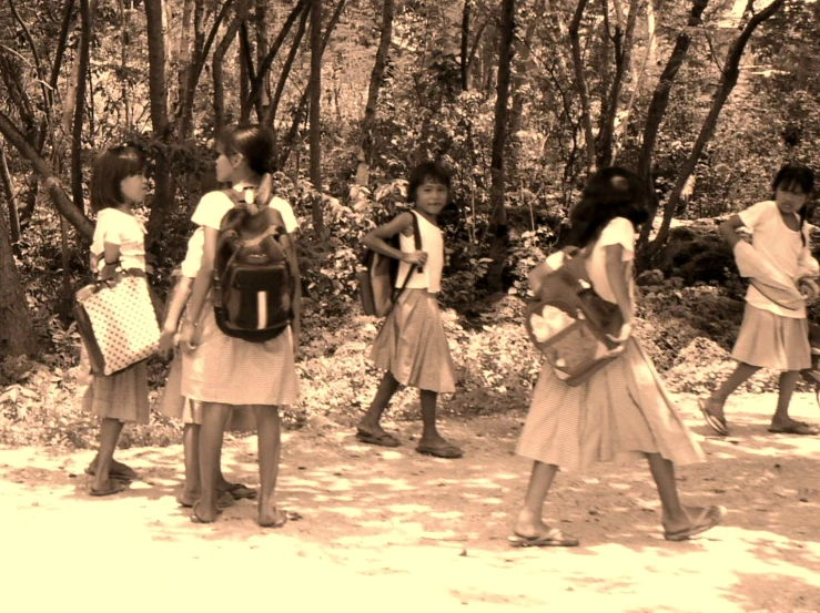 the school girls are walking in formation carrying their books