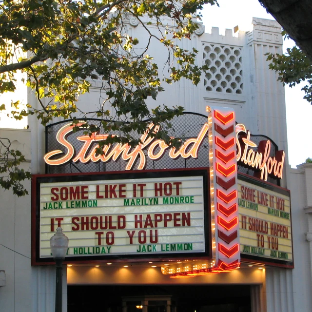 a picture of the front of a theater, with marquee signs