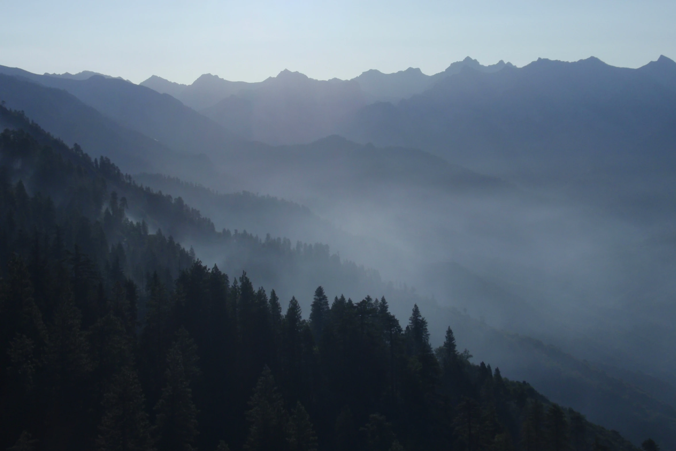 mountains covered in fog in the early evening