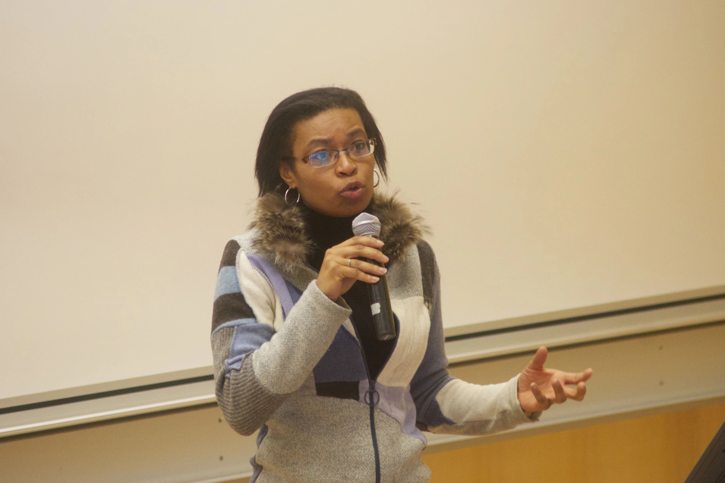 a woman talking into a microphone at a conference