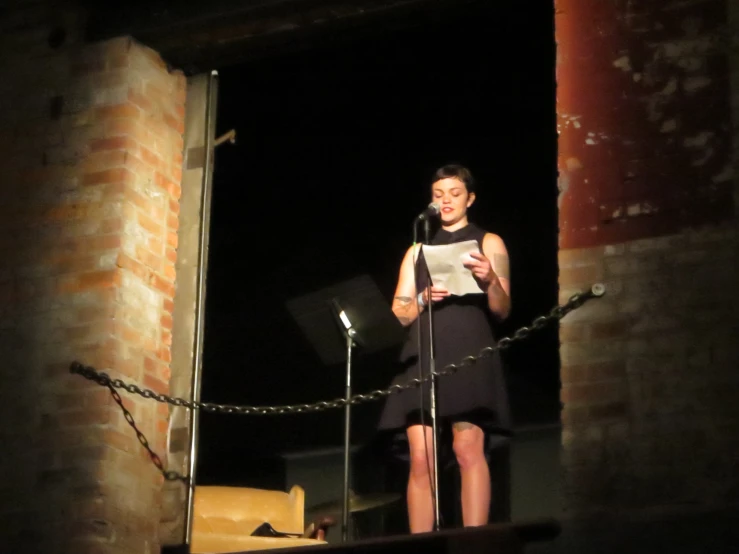 woman speaking into microphone surrounded by rope