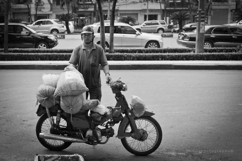 a person with bags on a motorcycle in the middle of a street