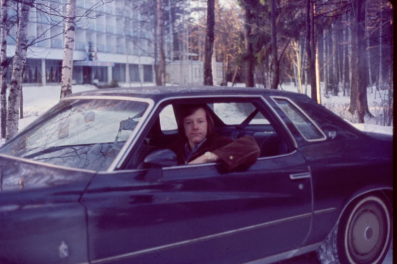 a woman sitting in the passenger seat of a blue car