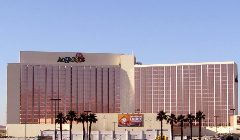 a view of an office building with palm trees in front