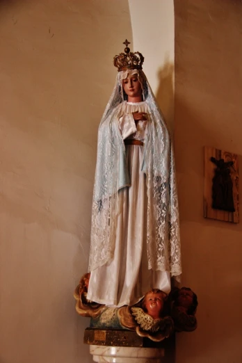 the statue of virgin mary and jesus is adorned with blue lace