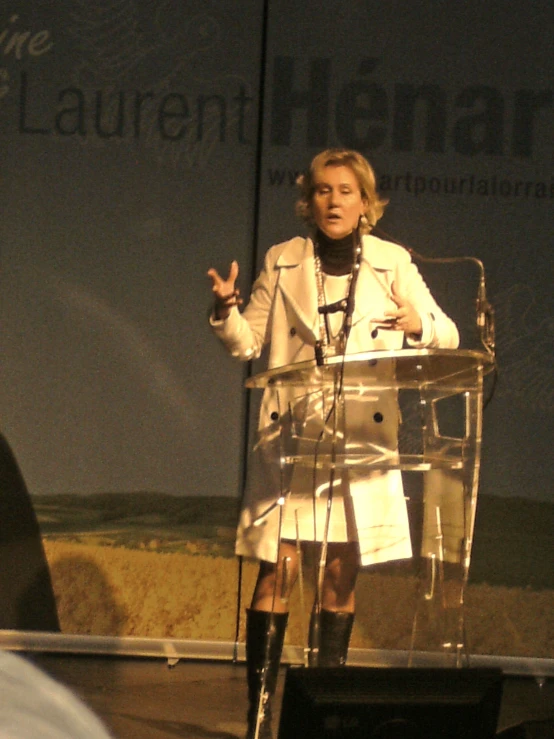 a woman in white speaking into a microphone