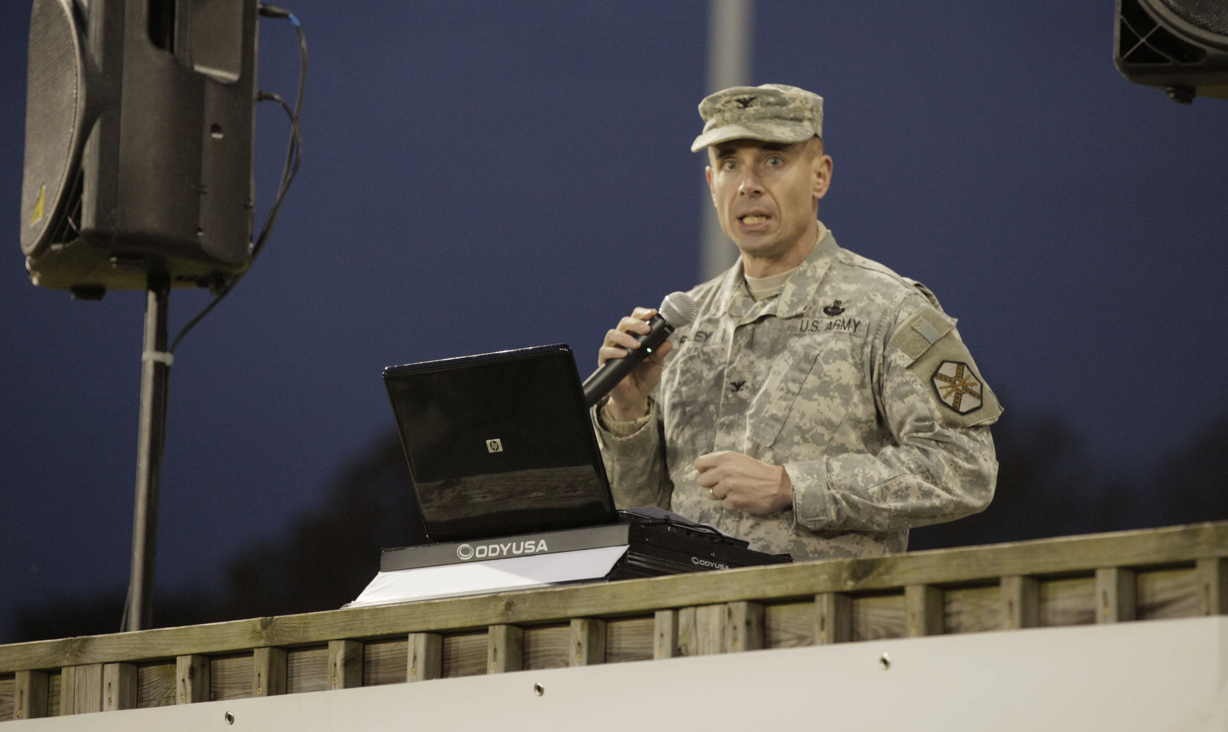 a man in uniform speaks on his laptop