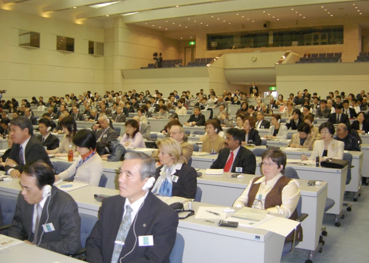 a group of people sitting at desks in a room