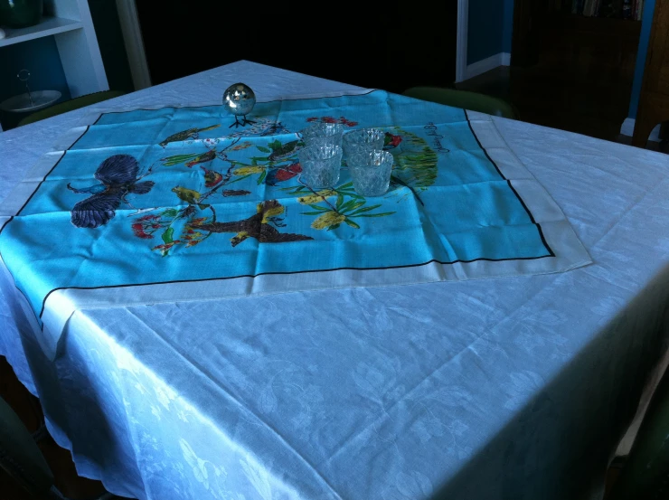 a table has a blue cloth with many fish on it