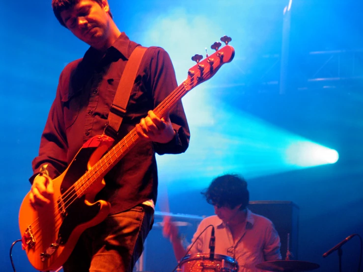 a man playing an instrument in front of a group of people