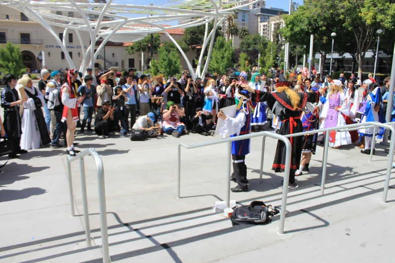 a crowd of people stand in front of a guard rail