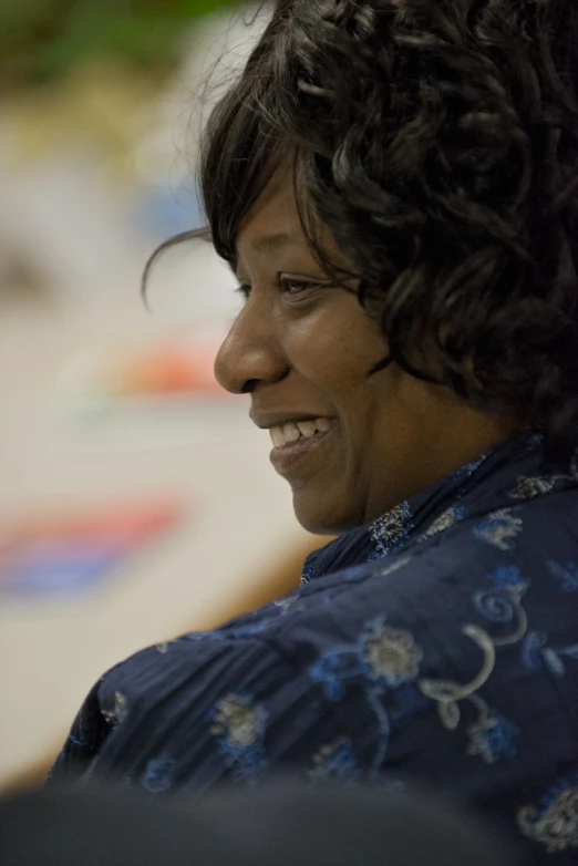 a woman smiles at the camera while she talks on her cell phone