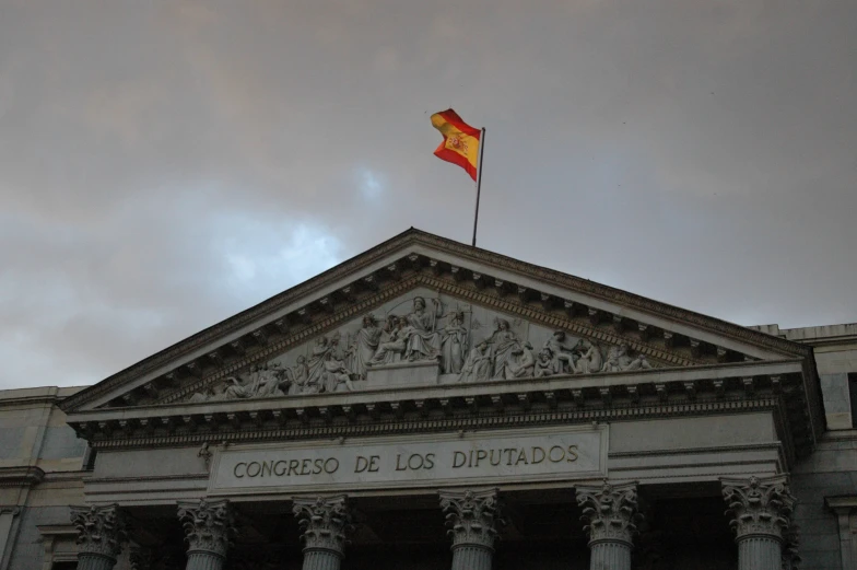 a large spanish building with a flag on top