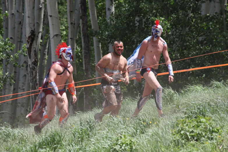 three people running a race in a field near trees