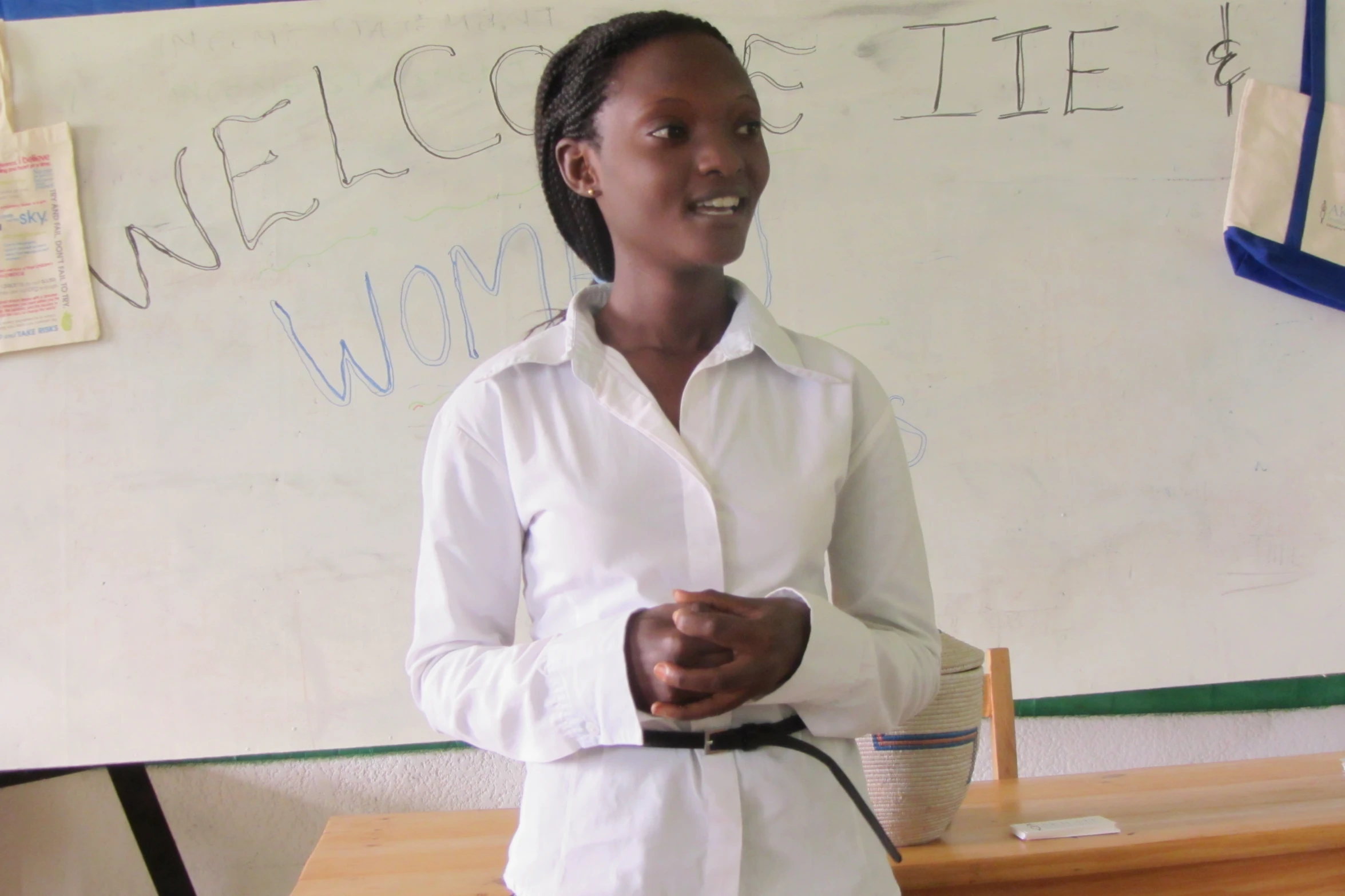 woman with white shirt and black belt in front of whiteboard