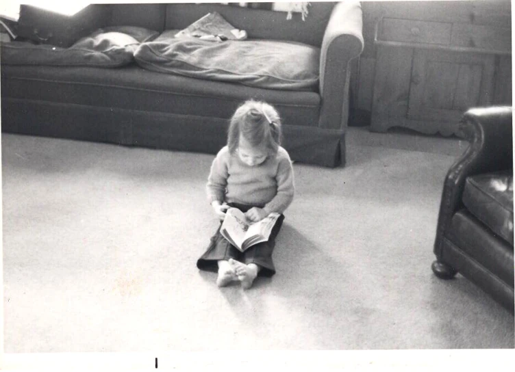 black and white image of a little girl reading a book