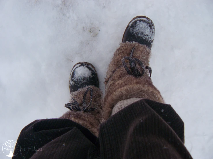 a person's feet in socks standing on snow