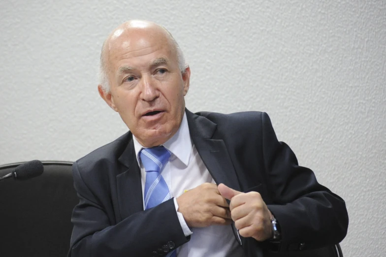 an older man in a business suit with a blue tie