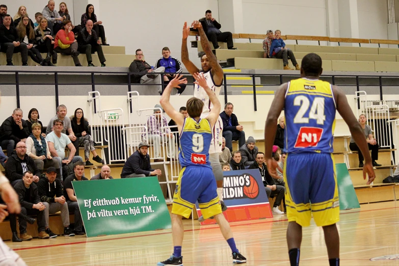 men playing basketball on a court in front of an audience