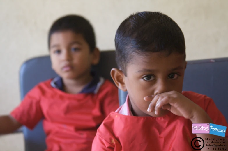 two children sitting at a table looking towards the camera