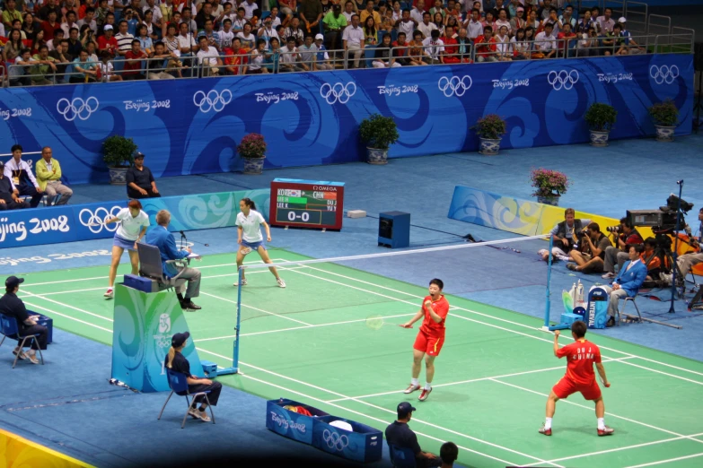 a group of people on a court playing tennis