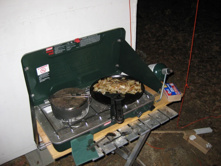 two pans of food on top of a stove in a room