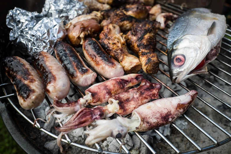 a grill with some meat and fish on it