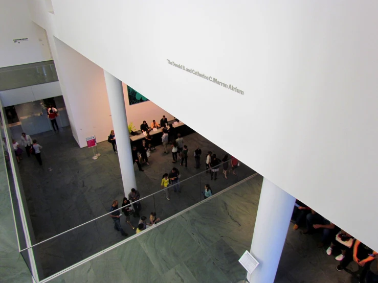 a large room has an interesting ceiling and some people