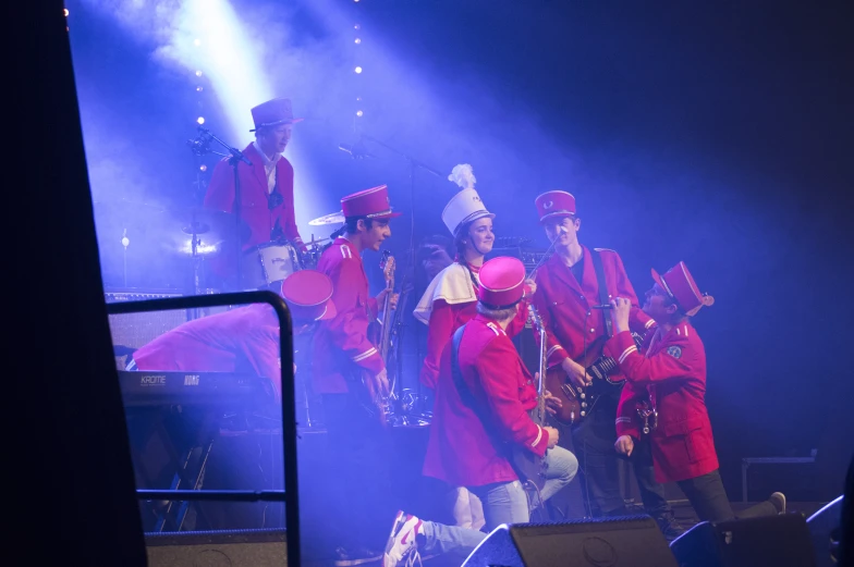 a group of musicians perform on stage in front of people