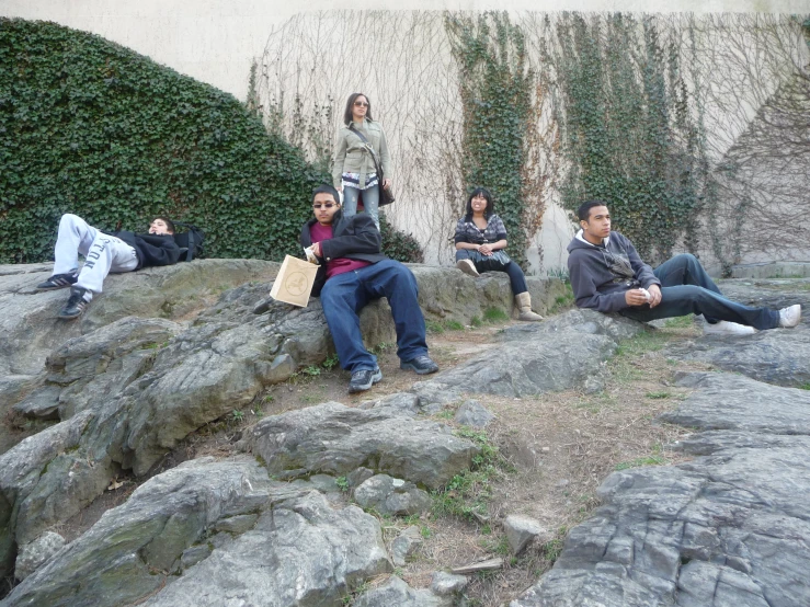 a group of people sitting on top of large rocks