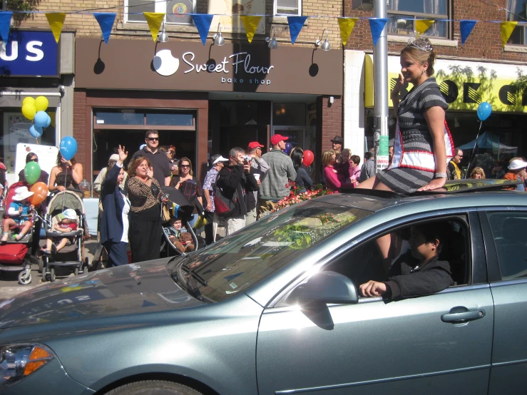 a group of people gather outside the store with balloons