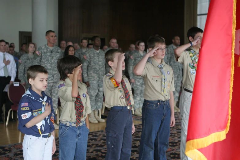 small boys wearing scout uniforms looking at an older man