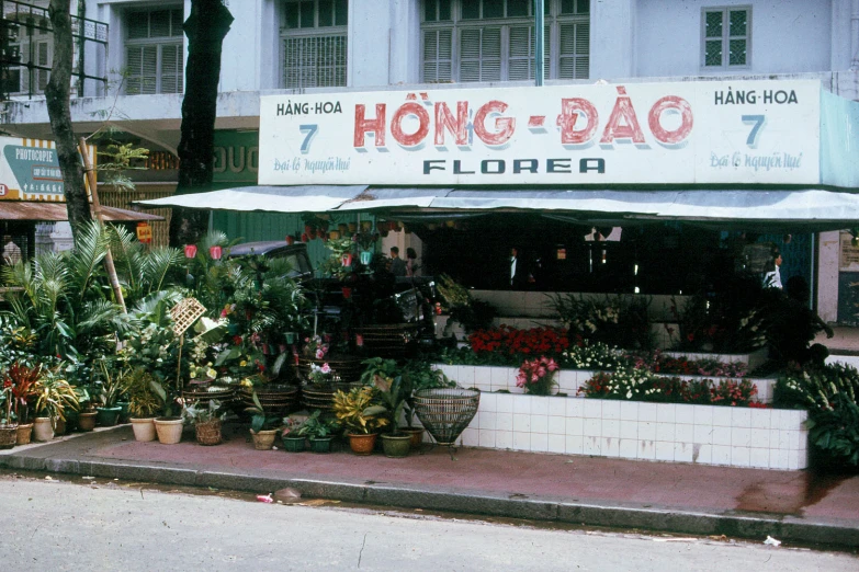 a long sidewalk with a flower shop on it