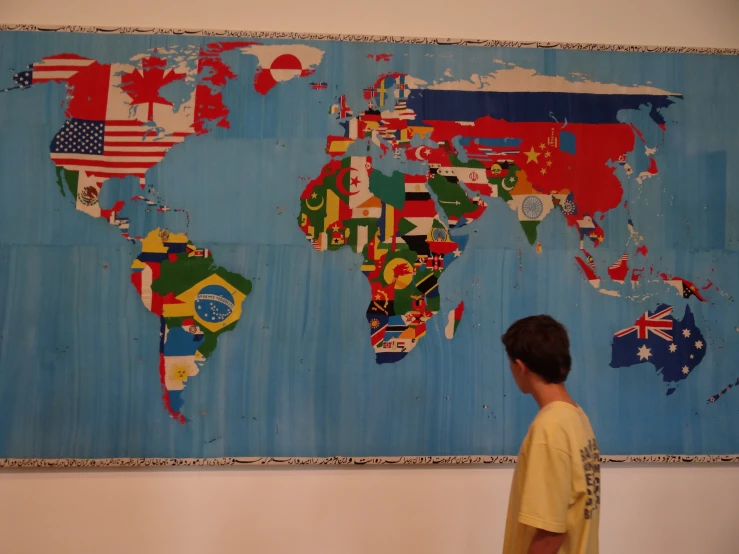 a boy looks at a map of the world made up of countries