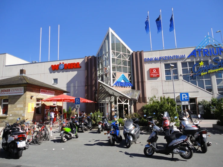 a group of people sitting on motorcycles parked in front of a building