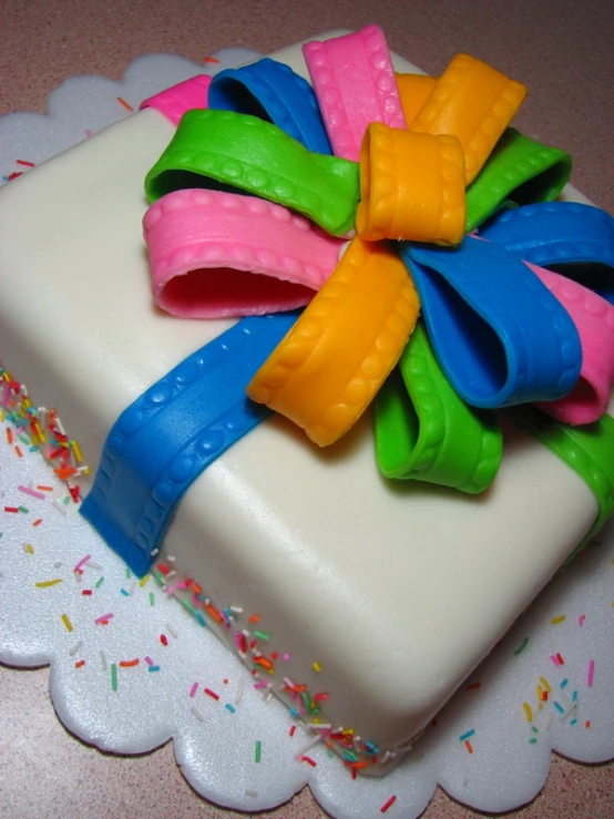 a cake with an unusual multi colored bow on it