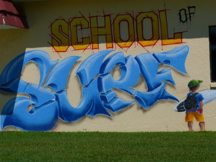 a person stands in front of a mural of the letters go blue