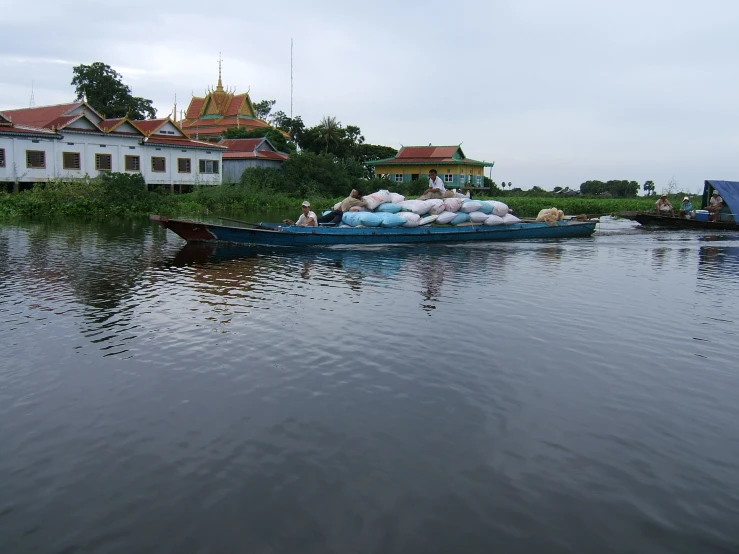 two boats filled with supplies sit on the river