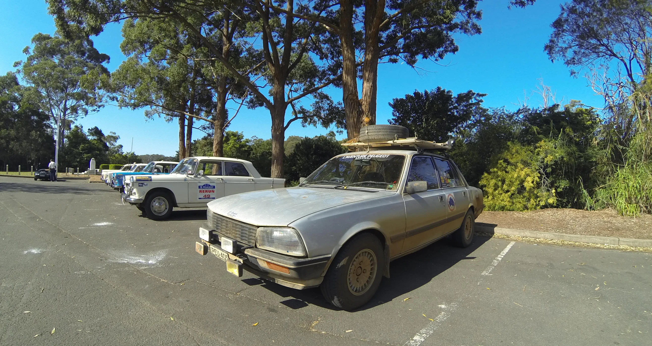 a car parked on the side of a street next to two other cars