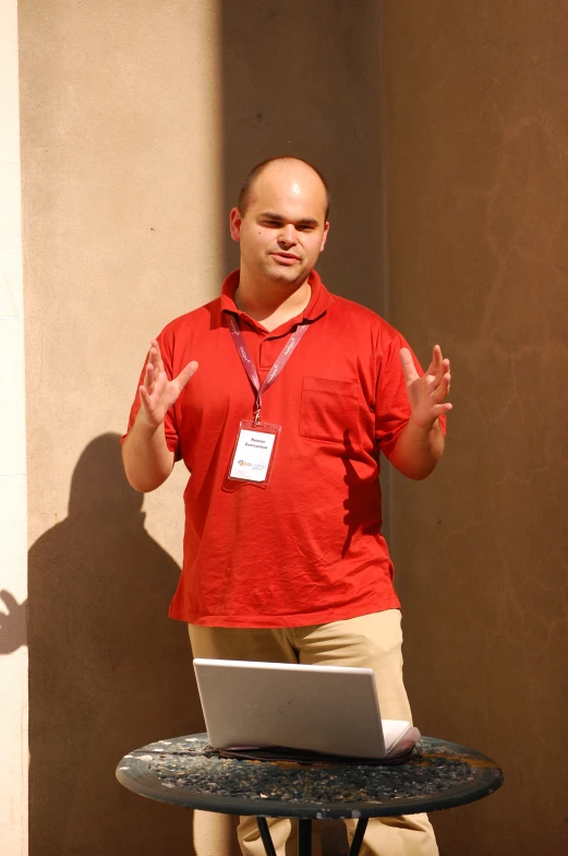 a man standing behind a laptop that is on display