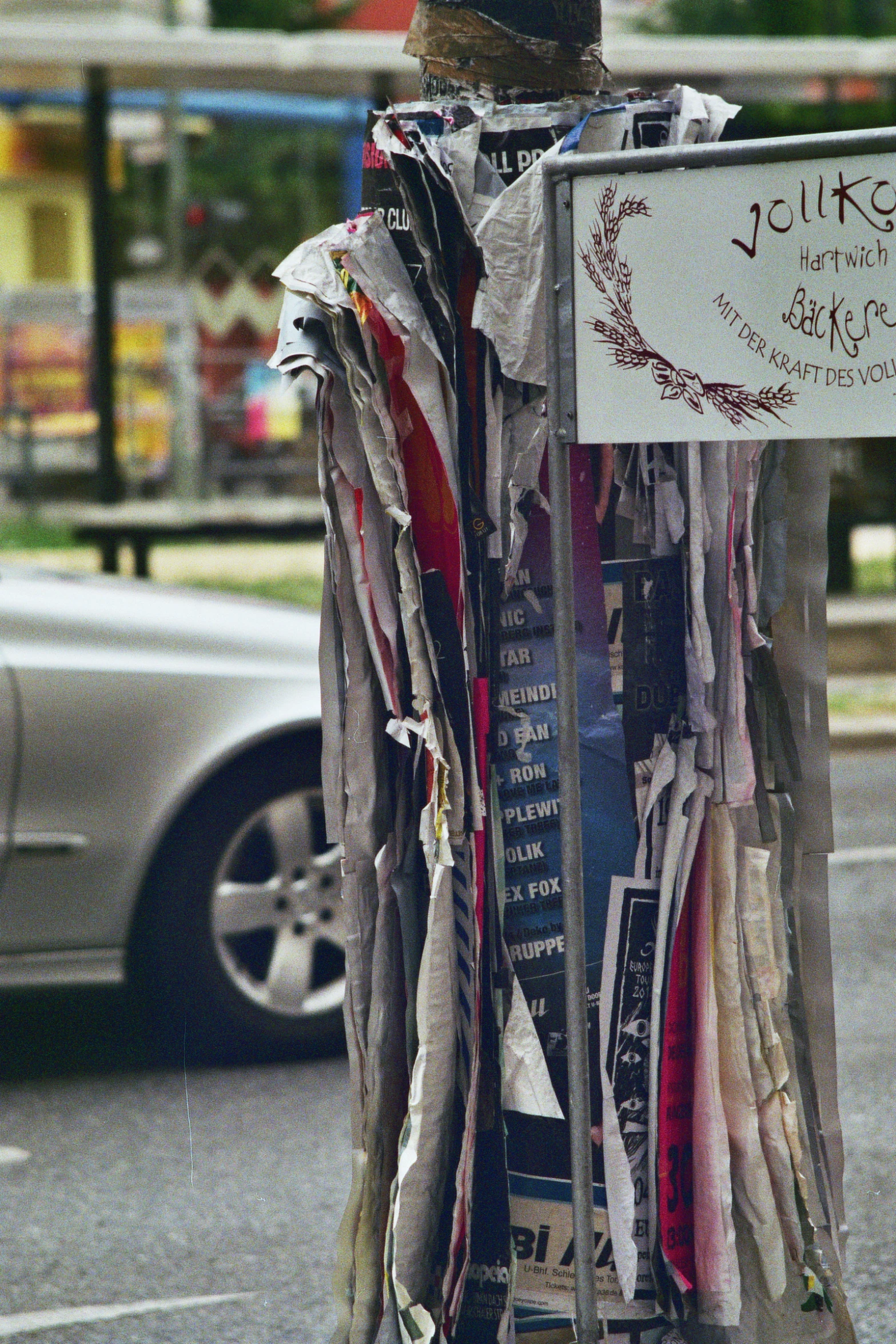 a close up of a street sign on a pole with paper around it