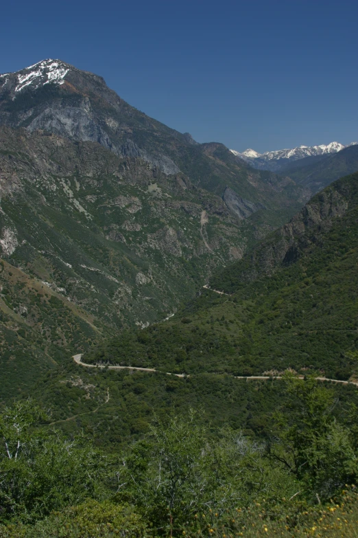 a mountain with snowy tops and a winding road in the foreground