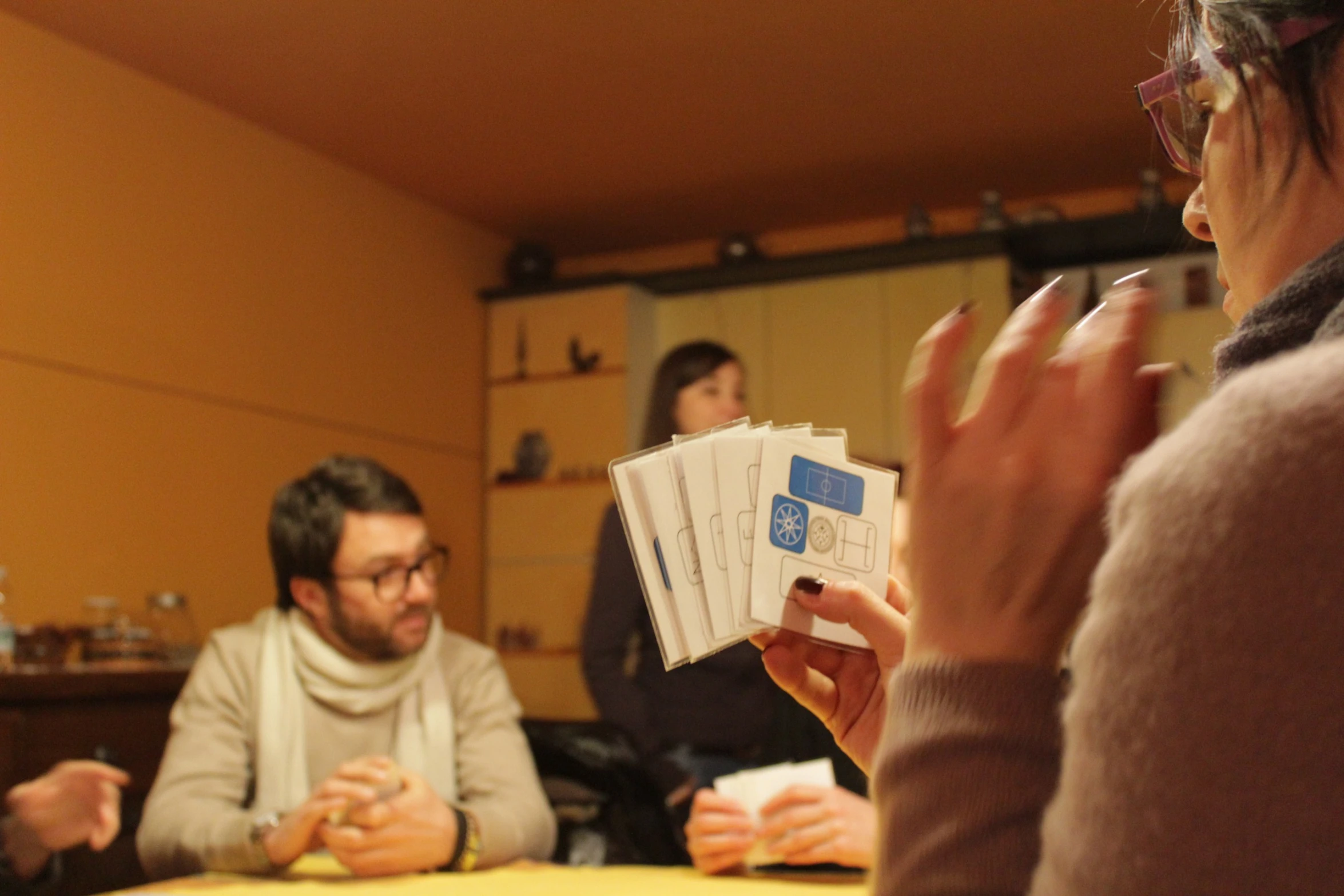 a woman holding a stack of papers in front of another person