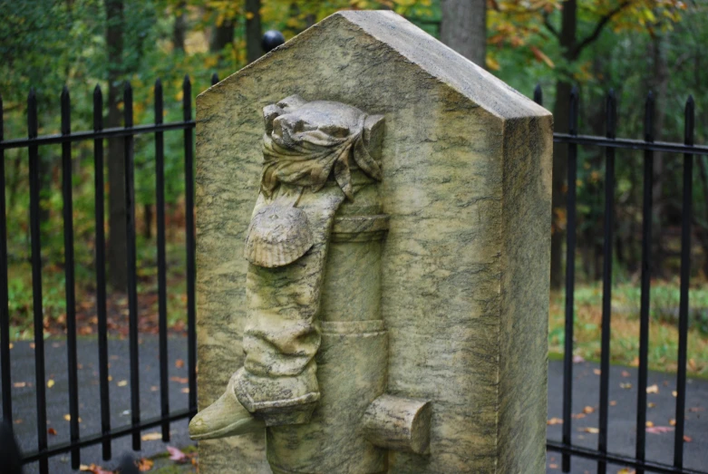 a stone memorial next to a fence in a park