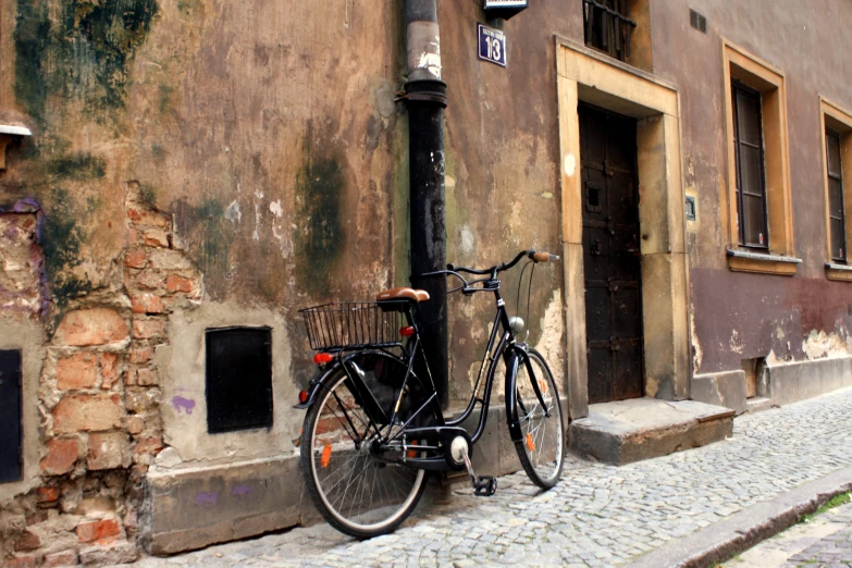bicycle parked against a pole in front of an old building