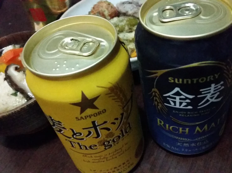 two cans sitting on a table next to some food