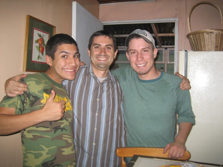 three young men posing for the camera with one holding his fist up