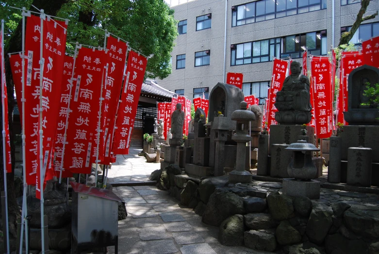 several signs hanging above rocks next to trees and buildings